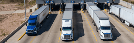 Semi-trucks crossing a border checkpoint, representing First Frontier Logistics' expertise in cross-border freight between Canada, USA, and Mexico.
