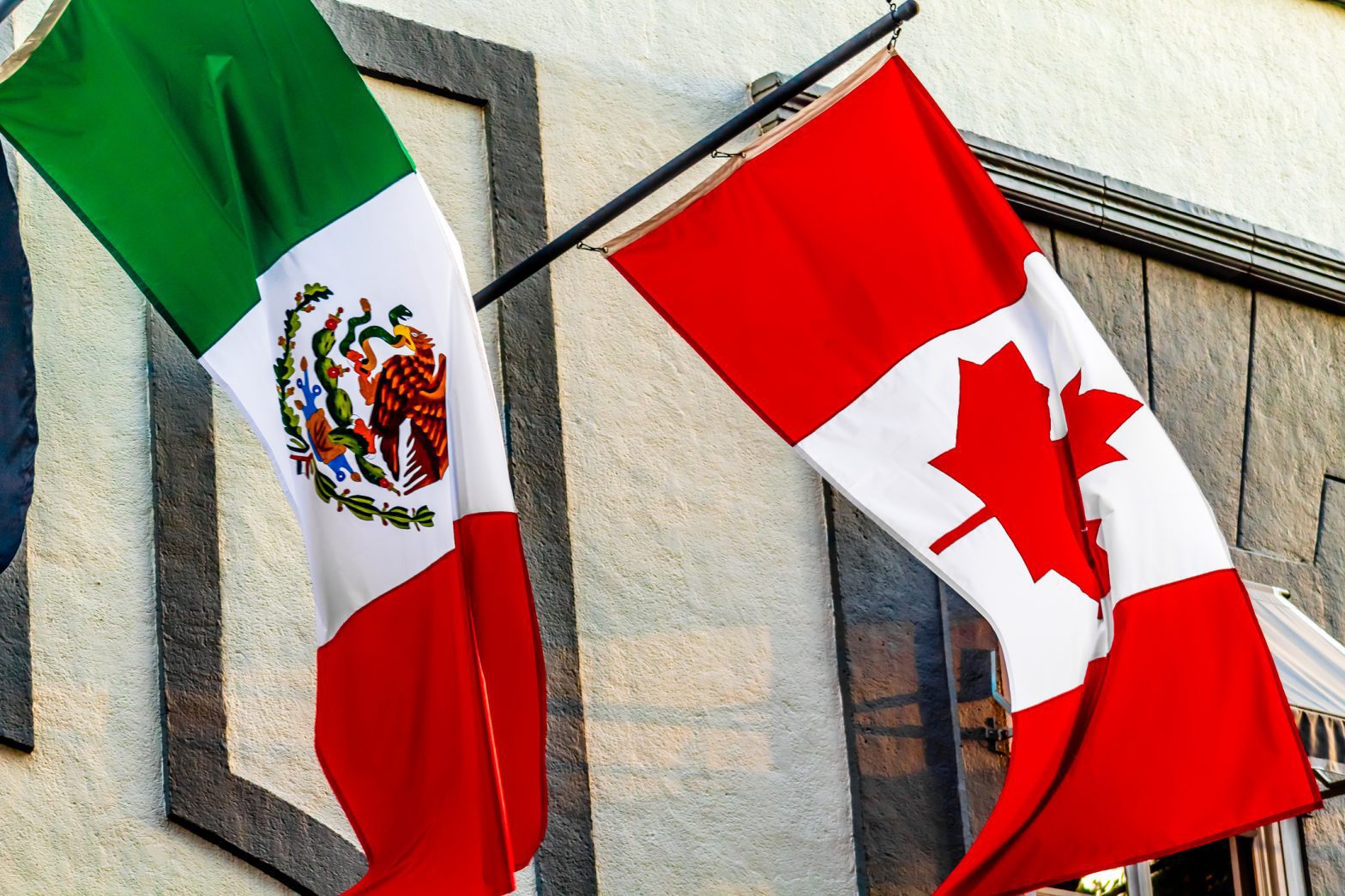 Mexican and Canadian national flags side by side, representing direct international trade and cross-border shipping without having to clear freight into the USA.