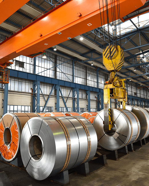 Steel coils stored in an industrial metal manufacturing facility.