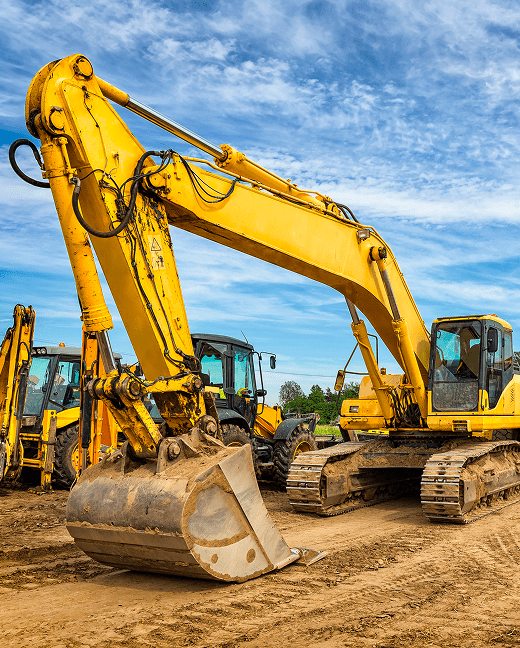 Yellow excavators and dump trucks parked at a construction site