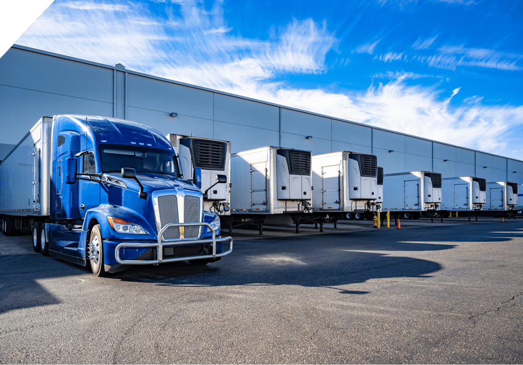 Heavy-duty blue transport truck parked at a warehouse loading dock, representing domestic freight shipping with reliable scheduling and efficient delivery.